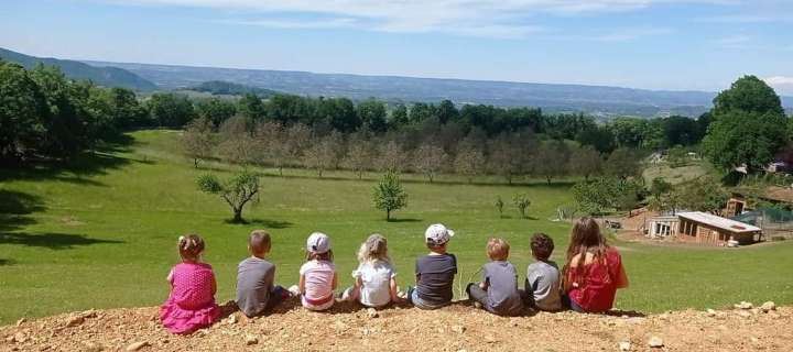 Vue panoramique du Vercors depuis la ferme, des enfants assis face au paysage